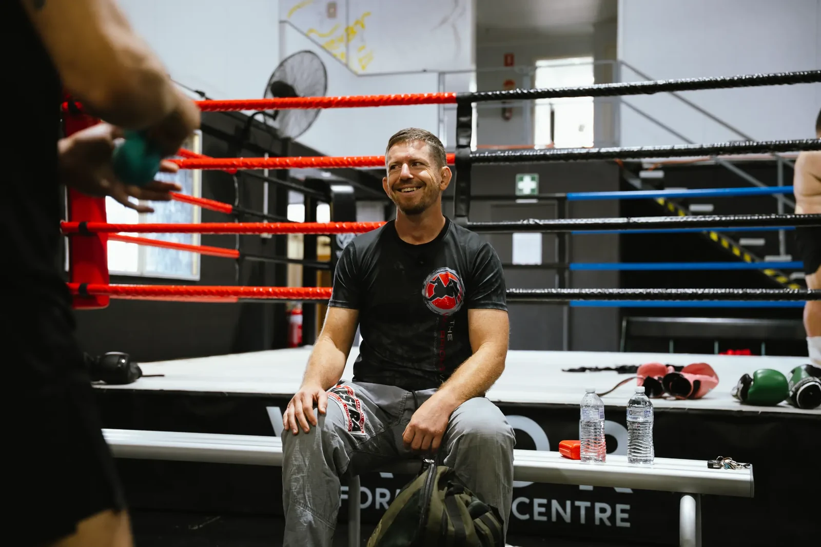 Brandt Cogill speaking with men beside the training ring